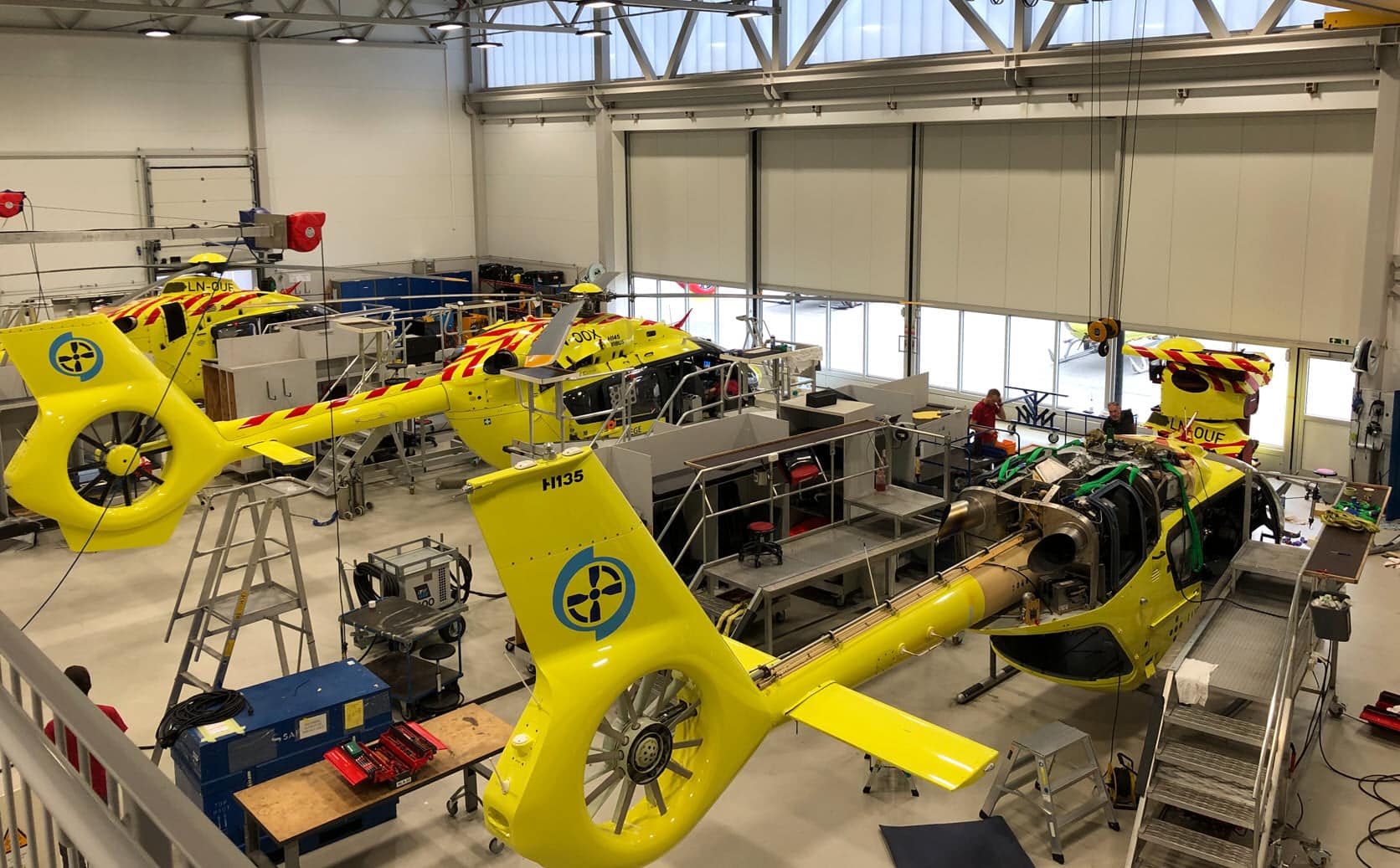 Bilde av helikoptre i teknisk hangar under reparasjon